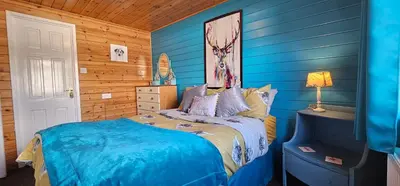 a bedroom with blue walls and a bed in it at Glen Roe - 3 Bed Lodge on Friendly Farm Stay in New Cumnock