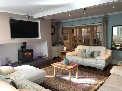 a living room with two white couches and a fireplace at Vollie House with Hot Tub, Sauna & Log Burner in Penpont
