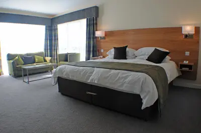 a bedroom with a large bed and a living room at Ramsey Park Hotel in Ramsey