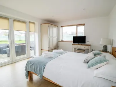 a bedroom with a large white bed and a television at Coney Garth Retreat in Beckermet