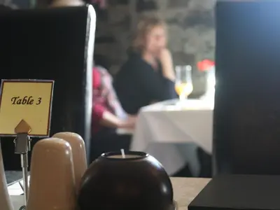 a woman sitting at a table with a glass of wine at The Bladnoch Inn in Bladnoch