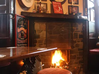a fireplace in a bar with a fire place at The Bladnoch Inn in Bladnoch