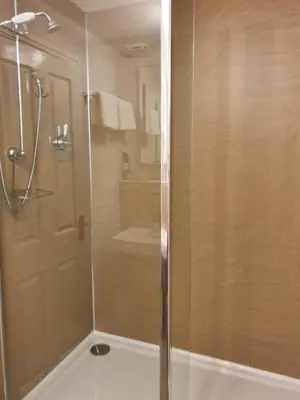 a shower with a glass door in a bathroom at Strathmore Guest House in Keswick