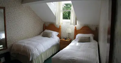 a bedroom with two beds and a window at Strathmore Guest House in Keswick