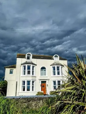a white house with an orange door on top of it at Westcliff in Seascale