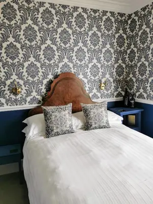 a bedroom with a white bed with a blue wall at Westcliff in Seascale