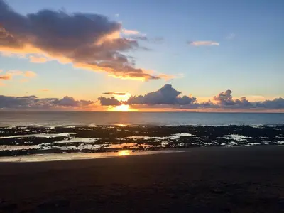 a sunset on the beach with the sun setting at Westcliff in Seascale
