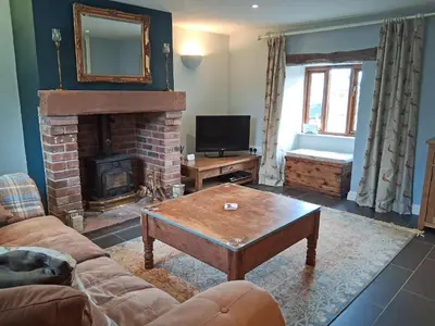 a living room with a couch and a fireplace at Swallow Barn in Torpenhow