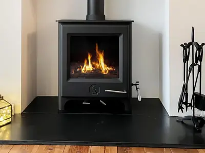 a fireplace in a living room with a fire at Otterbield in Keswick