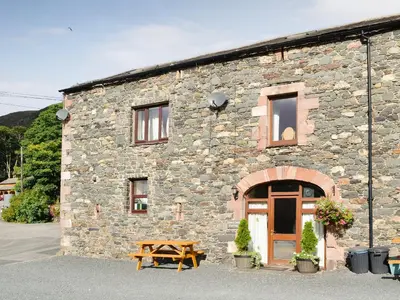 a stone building with a picnic table in front of it at Doddick Chase Cottage - Uk1363 in Threlkeld