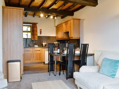 a kitchen and living room with a table and a couch at Doddick Chase Cottage - Uk1363 in Threlkeld