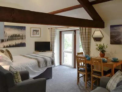 a bedroom with a bed and a desk with a television at Barn Owl Bothy in Westward