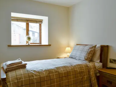 a bedroom with a bed with a window and a bed sidx sidx sidx at The Byres Tan in St Bees