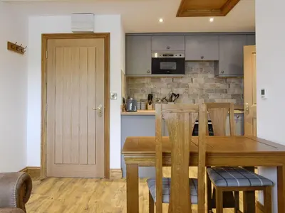 a kitchen and dining room with a wooden table and chairs at The Byres Methera in St Bees