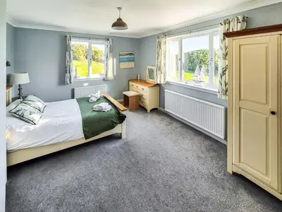 a bedroom with a bed and a desk and two windows at Gullsway in Glencaple