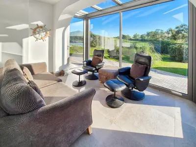 a living room with couches and chairs and a large window at Gullsway in Glencaple