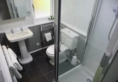 a small bathroom with a toilet and a sink at Limestone Lodges in Bothel