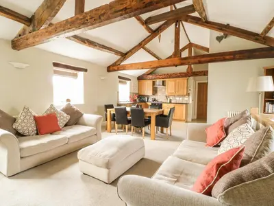 a living room with two couches and a table at Carleton Mill Cottage in Carlisle
