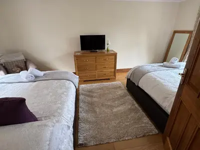 a bedroom with two beds and a tv on a dresser at The Haven in Keswick
