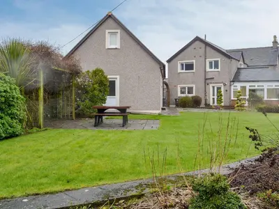 a house with a picnic table in the yard at Hawthorn Cottage in Stranraer