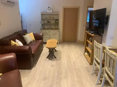 a living room with a brown couch and a television at Woodburn Lodges in Dumfries