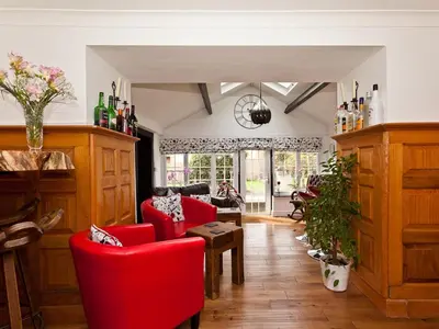 a living room with red chairs and a table at Littlebeck Warren in Whitehaven
