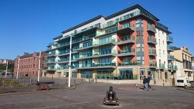 a large apartment building in front of a parking lot at Harbourside Apartment in Whitehaven