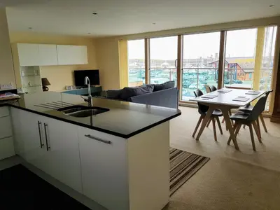 a kitchen and living room with a table and chairs at Harbourside Apartment in Whitehaven