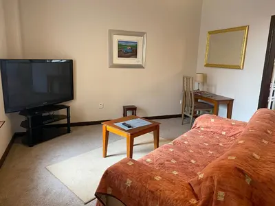 a living room with a couch and a tv at Welltrees Apartments 8 Dailly Road in Maybole