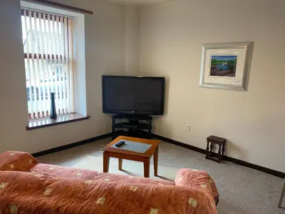 a living room with a couch and a flat screen tv at Welltrees Apartments 8 Dailly Road in Maybole