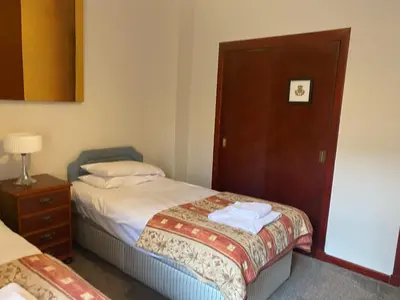 a hotel room with two beds and a wooden door at Welltrees Apartments 8 Dailly Road in Maybole