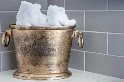 a metal bucket filled with white towels in a bathroom at Maxwelston Farmhouse in Girvan