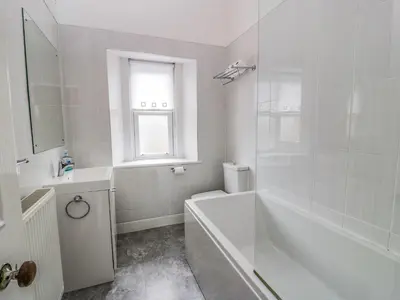 a white bathroom with a tub and a sink at Ayr Beach View Apartment in Ayr