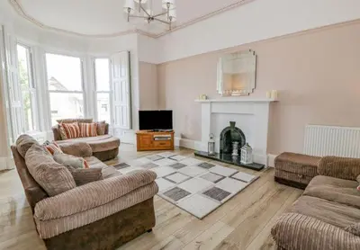 a living room with two couches and a fireplace at Ayr Beach View Apartment in Ayr