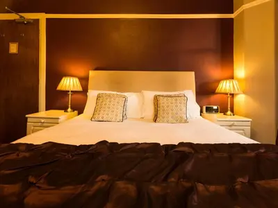 a bedroom with a large bed with two lamps at Craglands Guest House in Keswick