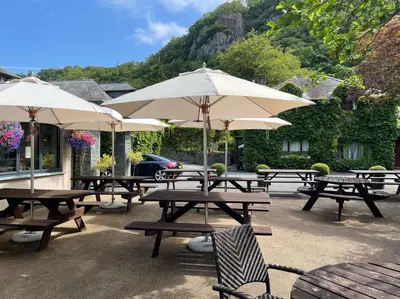 a group of picnic tables with umbrellas at The Mary Mount Hotel in Keswick