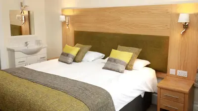 a bedroom with a large white bed with a sink at The Famous Star Hotel Moffat in Moffat