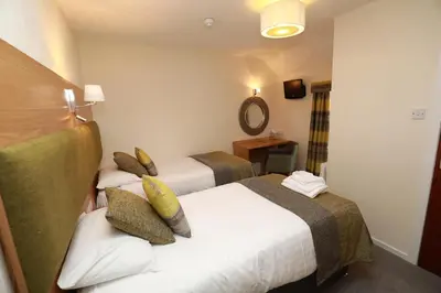 a hotel room with two beds and a mirror at The Famous Star Hotel Moffat in Moffat