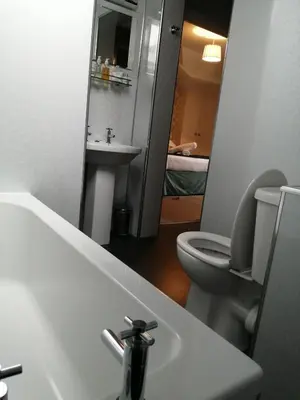 a bathroom with a sink and a toilet and a mirror at Allerdale Guest House in Keswick
