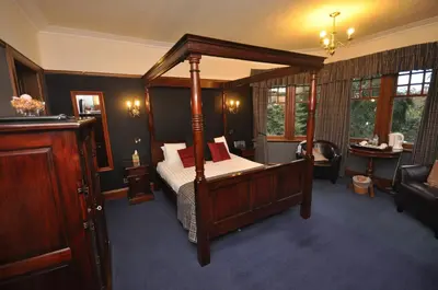 a bedroom with a canopy bed and a couch at Rivendell in Dumfries