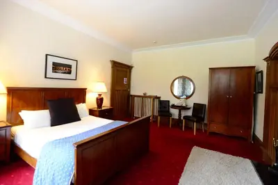 a hotel room with a bed and a mirror at Rivendell in Dumfries