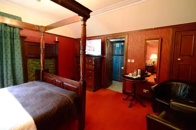 a bedroom with a bed and a desk and a television at Rivendell in Dumfries