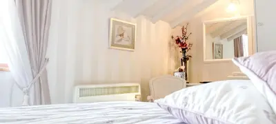 a white bedroom with a bed and a window at Bessiestown Country Guesthouse in Carlisle