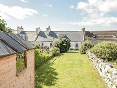 a view of the garden of the cottage with the house in the background at Greystones in Newton Stewart