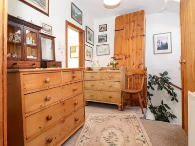a room with a wooden dresser and a chair at Castle Lodge in Keswick