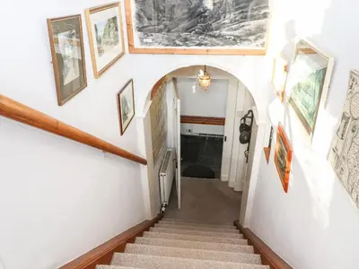 a staircase in a house with pictures on the walls at Castle Lodge in Keswick