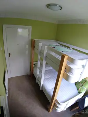 two bunk beds in a room with green walls at Fern Howe Guest House in Keswick