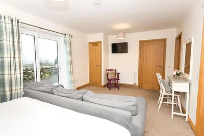 a living room with a couch and a table at Fleet View in Gatehouse of Fleet