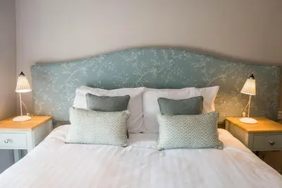a bed with two pillows on it with two lamps at The Horse and Farrier Inn and The Salutation Inn Threlkeld Keswick in Threlkeld
