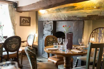 a dining room with a table and a fireplace at The Horse and Farrier Inn and The Salutation Inn Threlkeld Keswick in Threlkeld